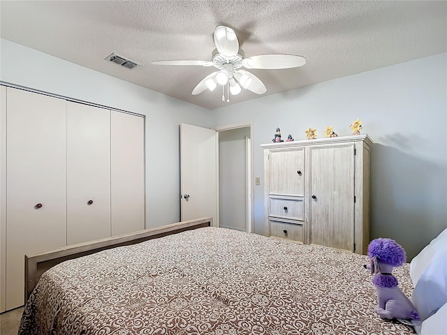 bedroom with ceiling fan, a closet, and a textured ceiling