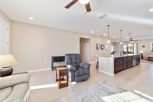 living room with ceiling fan, sink, and light tile patterned flooring