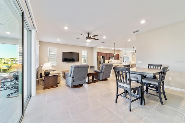 tiled dining space featuring ceiling fan