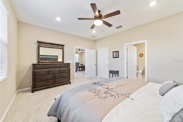 carpeted bedroom with ceiling fan and ensuite bath