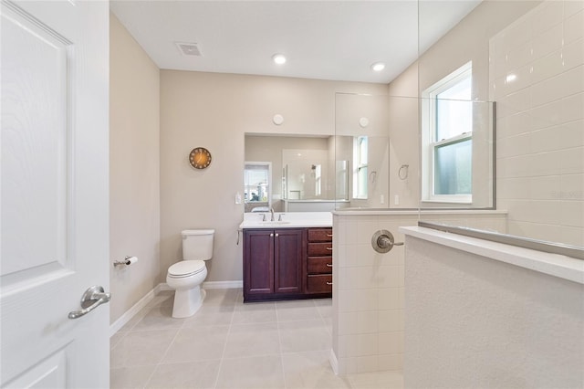 bathroom with tile patterned floors, vanity, toilet, and a shower