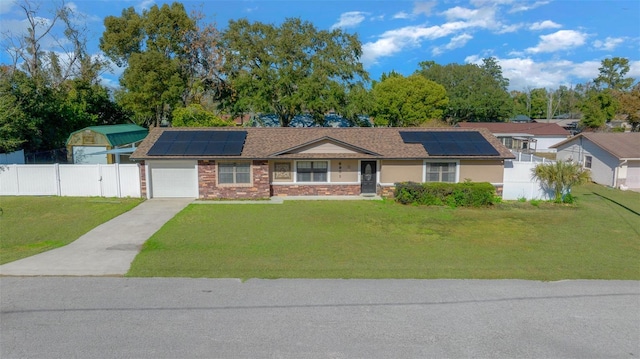 single story home featuring solar panels, a garage, and a front lawn