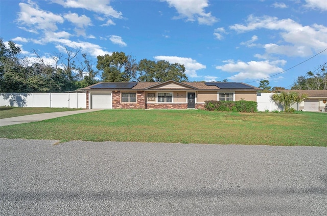 single story home with a front yard, solar panels, and a garage