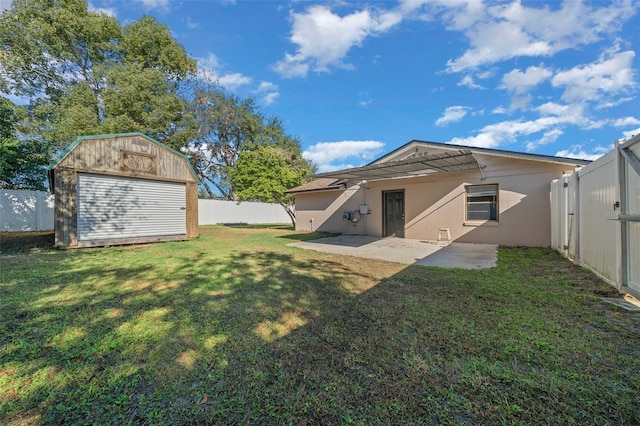 back of house featuring a lawn, a patio, and a storage unit