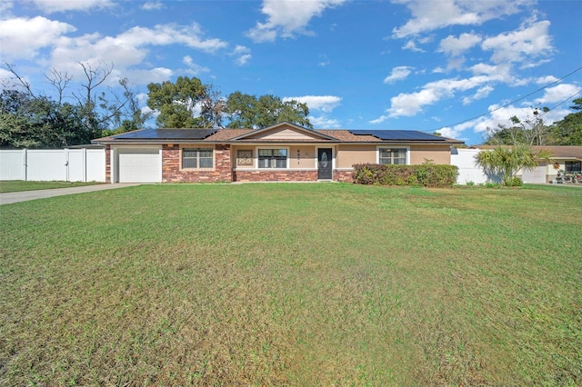 single story home with solar panels, a garage, and a front lawn