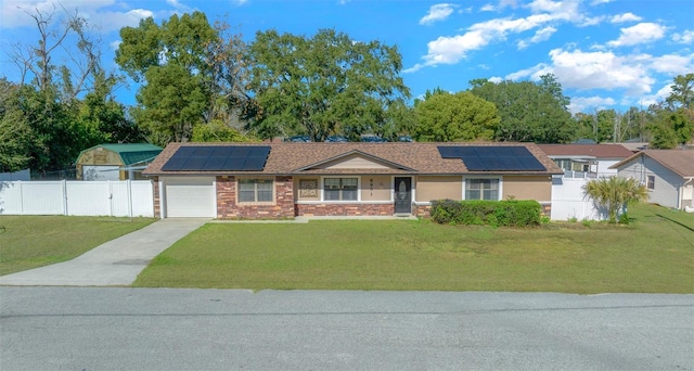 ranch-style house with solar panels, a garage, and a front lawn