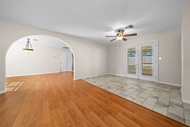 unfurnished room with ceiling fan, french doors, and light tile patterned floors