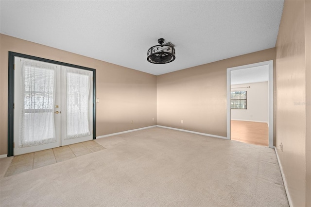 carpeted spare room featuring french doors