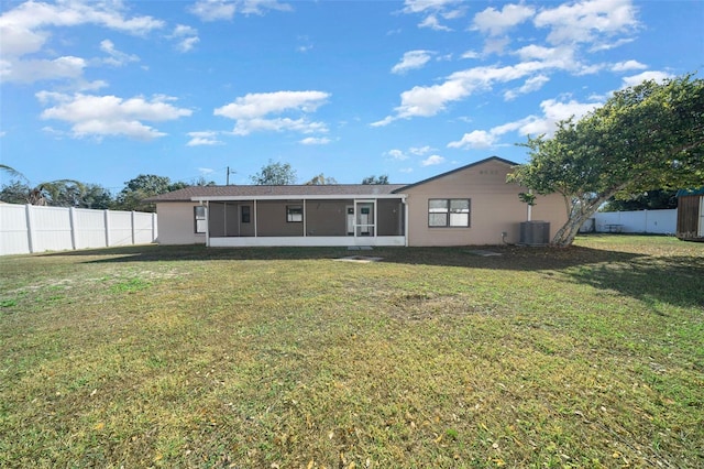 rear view of property with a sunroom, a yard, and central air condition unit