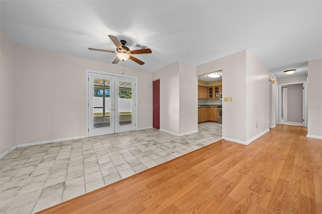 tiled empty room with ceiling fan and french doors