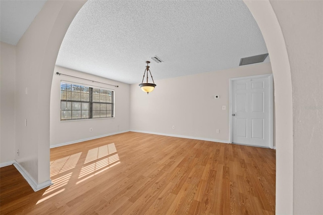 spare room featuring wood-type flooring and a textured ceiling