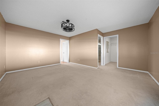 unfurnished bedroom featuring light colored carpet, a spacious closet, and a closet