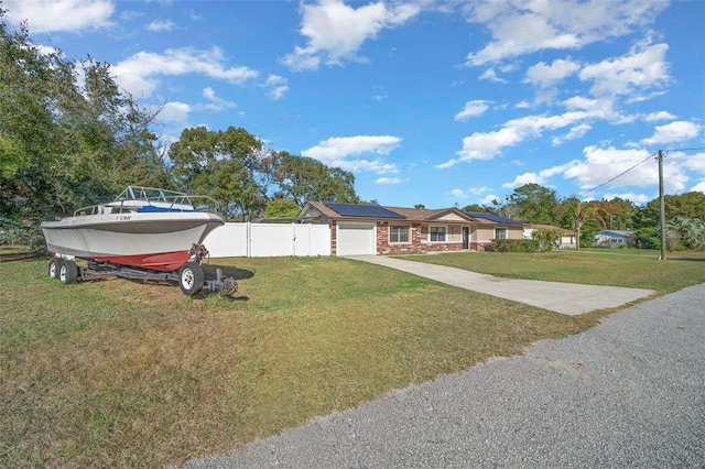 view of front of home with solar panels and a front lawn