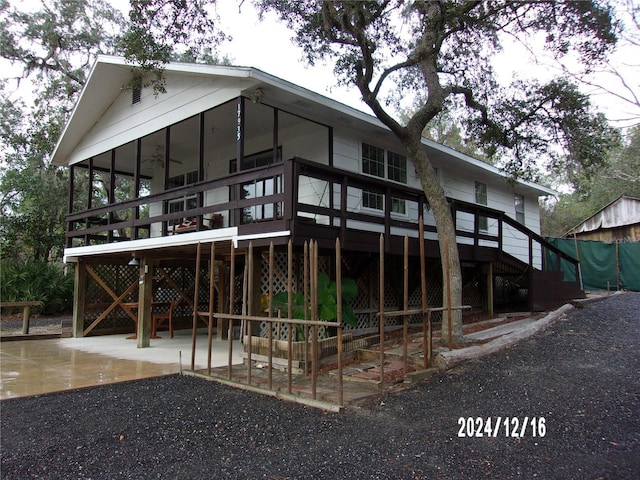 rear view of house featuring ceiling fan