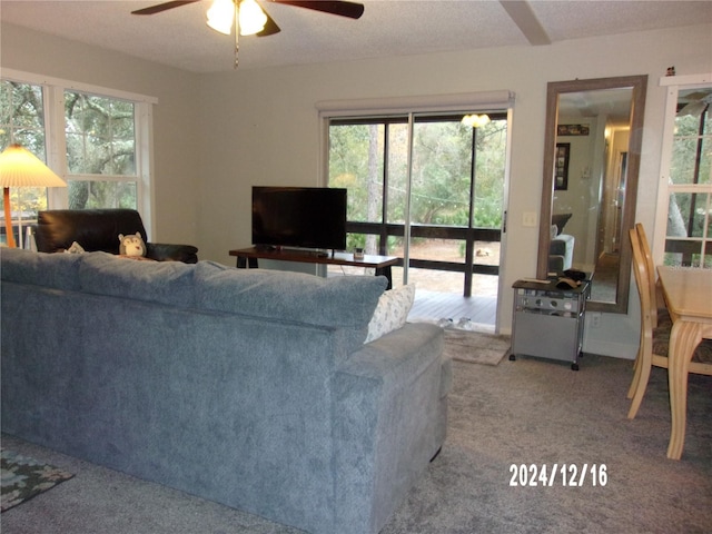 carpeted living room featuring a textured ceiling and ceiling fan