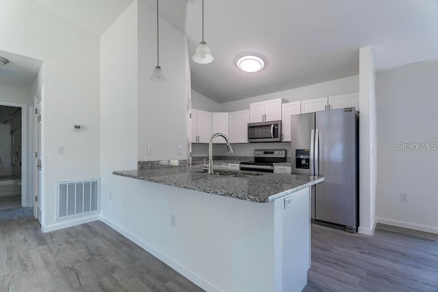 kitchen featuring pendant lighting, sink, kitchen peninsula, white cabinetry, and stainless steel appliances