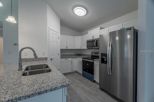 kitchen featuring hanging light fixtures, sink, kitchen peninsula, appliances with stainless steel finishes, and white cabinetry