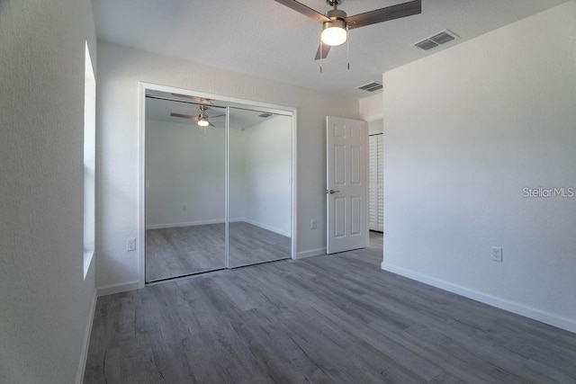 unfurnished bedroom featuring ceiling fan, wood-type flooring, and a closet