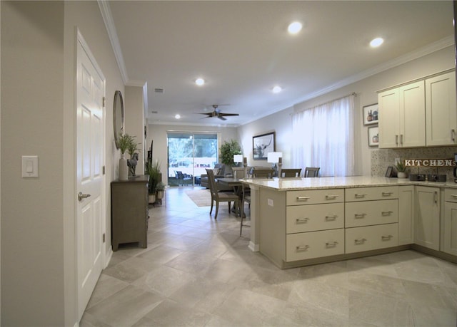 kitchen with kitchen peninsula, light stone countertops, tasteful backsplash, ornamental molding, and ceiling fan