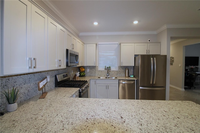 kitchen with tasteful backsplash, light stone counters, stainless steel appliances, sink, and white cabinetry