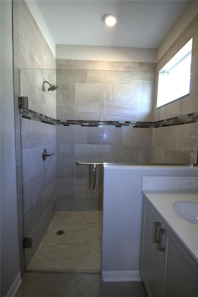 bathroom featuring vanity and a shower with shower door