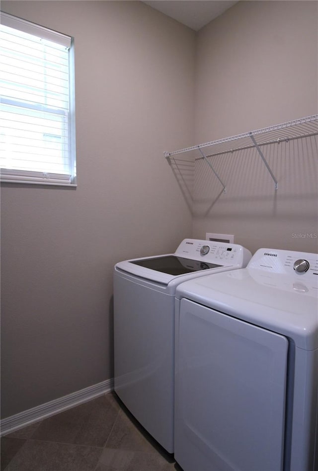 laundry area featuring dark tile patterned floors and washing machine and clothes dryer