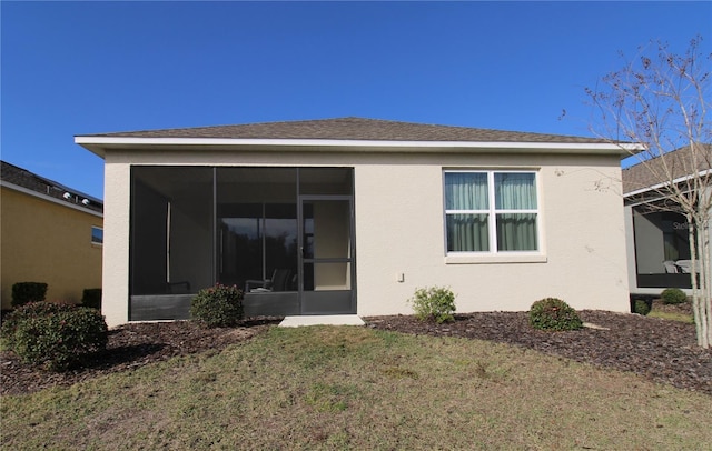 rear view of property featuring a lawn and a sunroom