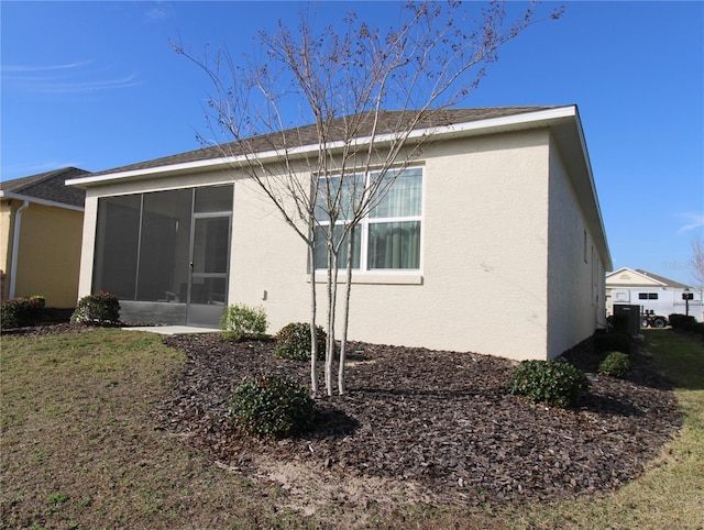 rear view of house featuring a yard and a sunroom