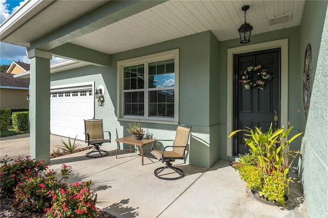 entrance to property featuring a porch and a garage