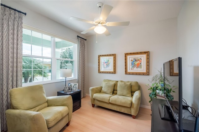 living area with light wood-type flooring, plenty of natural light, and ceiling fan