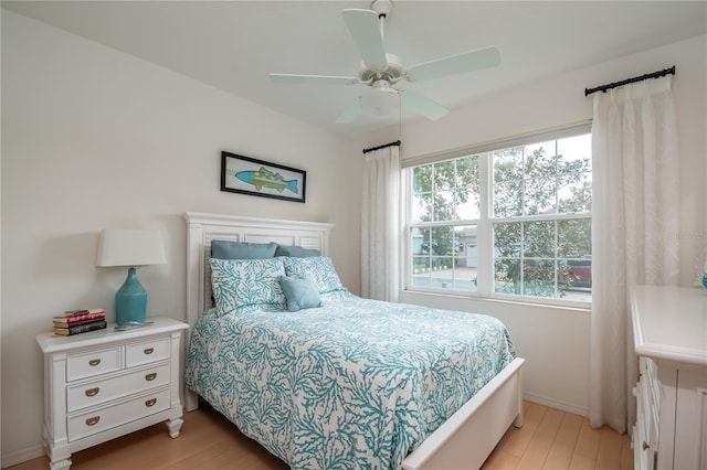 bedroom featuring multiple windows, light hardwood / wood-style floors, and ceiling fan