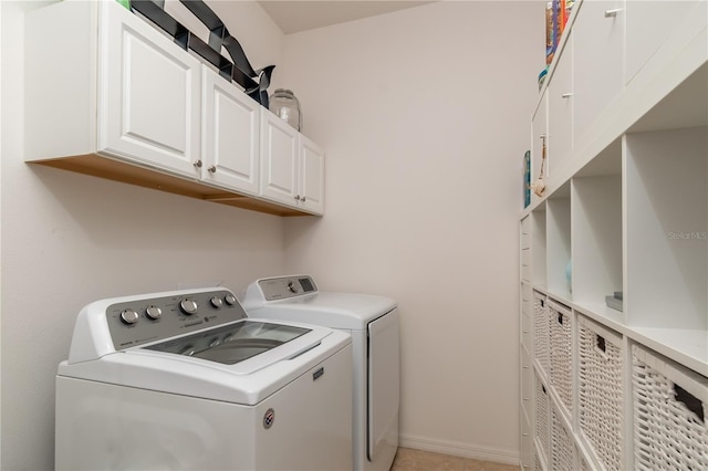 laundry room with washing machine and dryer and cabinets