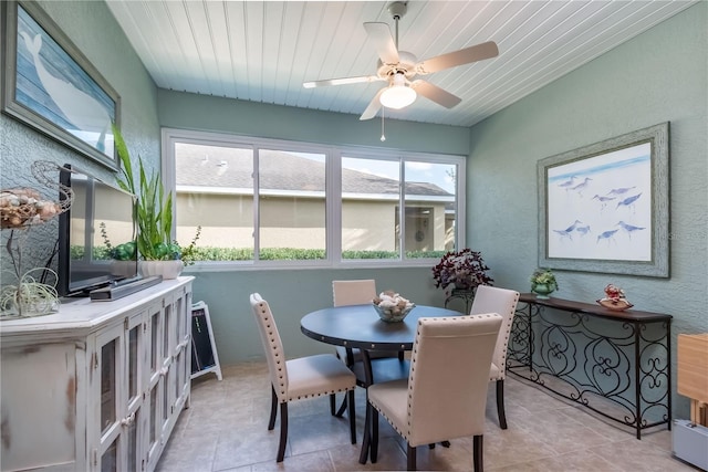 tiled dining room with ceiling fan and wooden ceiling