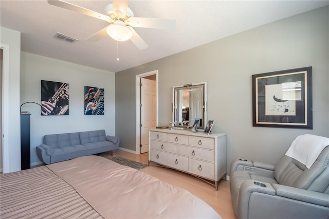 bedroom featuring ceiling fan, light hardwood / wood-style floors, and a textured ceiling