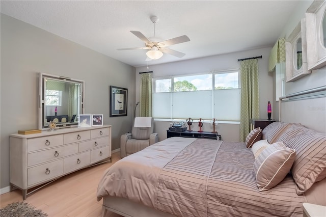 bedroom featuring ceiling fan, light hardwood / wood-style floors, and a textured ceiling