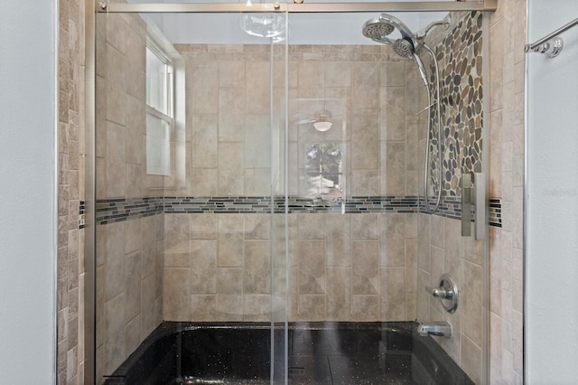 bathroom with bath / shower combo with glass door