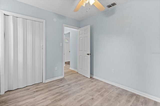 unfurnished bedroom with ceiling fan, light hardwood / wood-style floors, and a closet