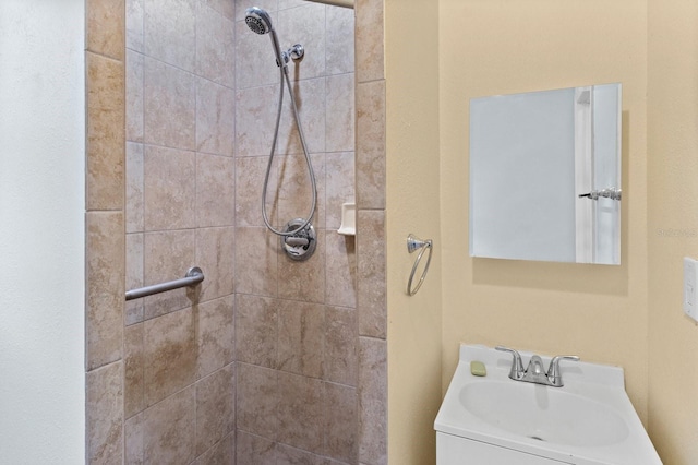 bathroom with a tile shower and vanity