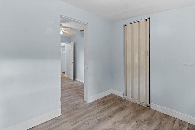 empty room with light wood-type flooring and ceiling fan