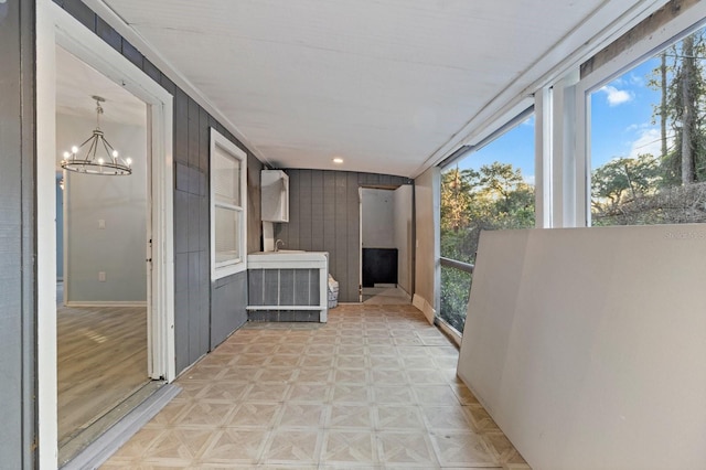 unfurnished sunroom with a chandelier