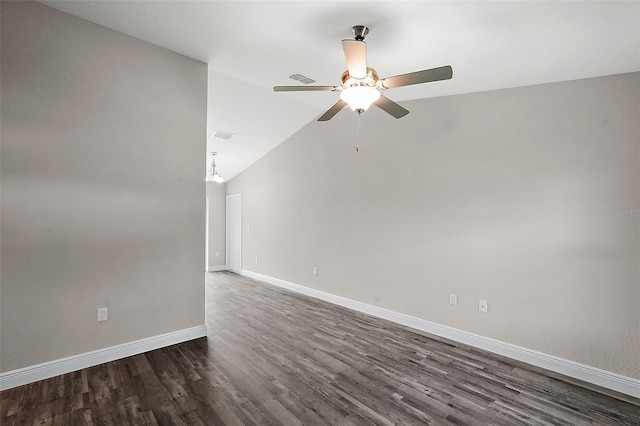 empty room featuring ceiling fan with notable chandelier, dark wood-type flooring, and lofted ceiling