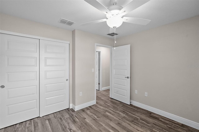 unfurnished bedroom featuring hardwood / wood-style floors, a closet, and ceiling fan