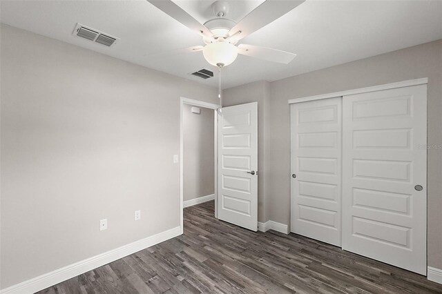 unfurnished bedroom featuring dark hardwood / wood-style flooring, a closet, and ceiling fan