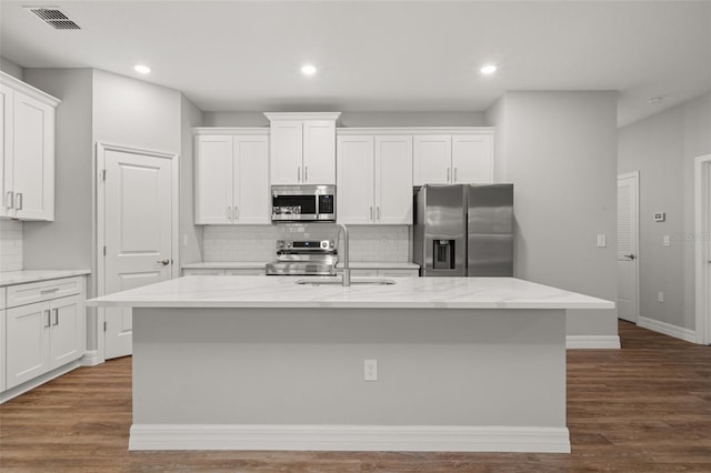 kitchen featuring appliances with stainless steel finishes, white cabinetry, a kitchen island with sink, and sink