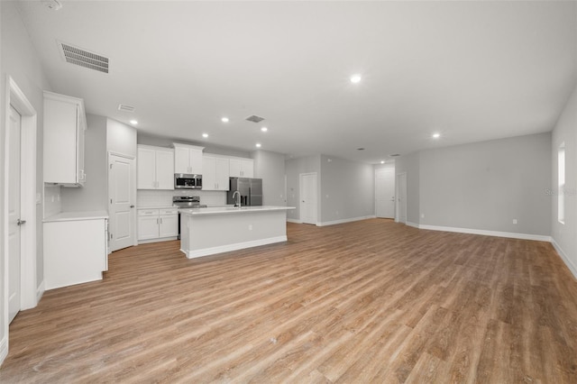 unfurnished living room featuring sink and light wood-type flooring