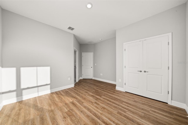 unfurnished bedroom with hardwood / wood-style flooring and a closet