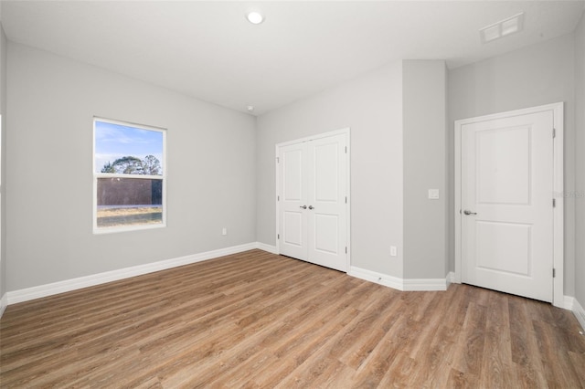 unfurnished bedroom featuring a closet and hardwood / wood-style floors