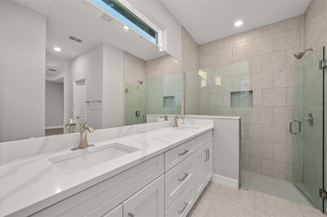 bathroom featuring a shower with door and vanity