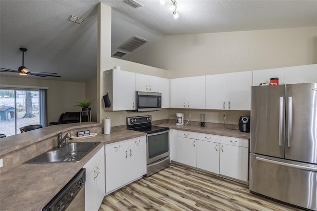 kitchen with a textured ceiling, sink, white cabinetry, and stainless steel appliances