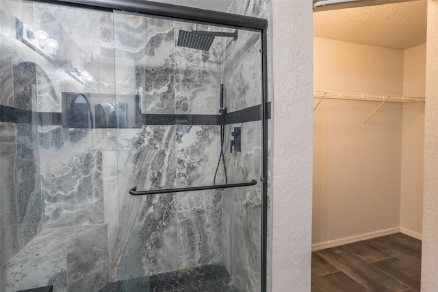 bathroom featuring a shower with shower door and a textured ceiling